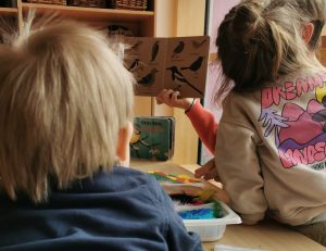 Zwei Kinder schauen sich ein Vogelbuch an